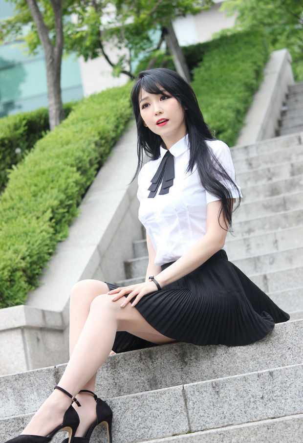 Pretty Asian In A Black Skirt & White Top Sitting On The Steps