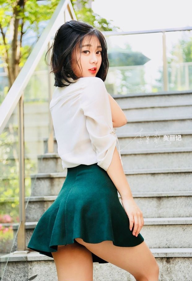 Sweet Asian In A White Blouse & Green Skirt Walking Up The Stairs